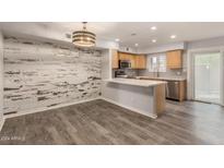 Kitchen features a breakfast bar, modern appliances, and wood-look flooring at 1425 E Desert Cove Ave # 43, Phoenix, AZ 85020