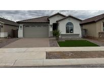 Two-car garage with neutral-toned exterior and artificial turf at 24066 N 162Nd Ln, Surprise, AZ 85387