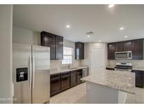 Well-equipped kitchen with stainless steel appliances and granite counters at 8208 W Albeniz Pl, Phoenix, AZ 85043