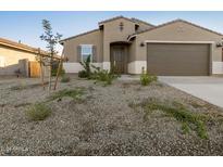 Single-story home with a two-car garage and desert landscaping at 20319 N 224Th Dr, Surprise, AZ 85387