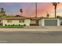 Charming single story home with a modern gray garage door at 8247 E Devonshire Ave, Scottsdale, AZ 85251