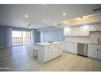 Updated kitchen boasts white cabinets, stainless steel appliances, and marble countertops at 7920 E Camelback Rd # 612, Scottsdale, AZ 85251