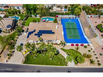 Aerial view of luxury home with pool, sports court, and lush landscaping at 10512 E Cortez Dr, Scottsdale, AZ 85259