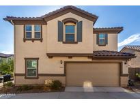 Two story house with tan exterior and two car garage at 16256 W La Ventilla Way, Goodyear, AZ 85338