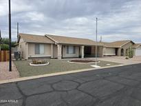 Single story home with landscaped yard and carport at 7857 E Flossmoor Ave, Mesa, AZ 85208