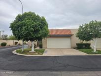 Tan stucco condo with a two-car garage and mature trees at 3345 E University Dr # 25, Mesa, AZ 85213