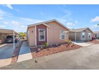 Tan and maroon manufactured home with carport and small landscaping at 6835 W Taylor St # 208, Phoenix, AZ 85043