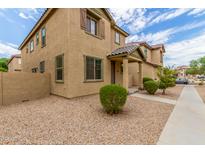 Two story tan house with landscaping and a walkway at 915 E Agua Fria Ln, Avondale, AZ 85323