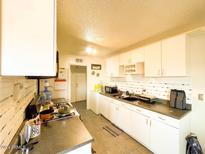 Bright kitchen with white cabinets and tiled backsplash at 6767 N 7Th St # 217, Phoenix, AZ 85014