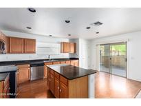 Kitchen with island, stainless steel appliances, and patio access at 8531 N 64Th Ave, Glendale, AZ 85302