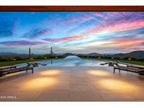 Infinity pool with mountain views at sunset at 42515 N 102Nd St, Scottsdale, AZ 85262
