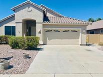 Tan one-story home with three car garage at 29922 N Little Leaf Dr, San Tan Valley, AZ 85143