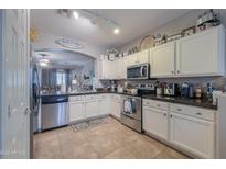 Modern kitchen with white cabinets, granite countertops, and stainless steel appliances at 1594 E Desert Breeze Dr, Casa Grande, AZ 85122