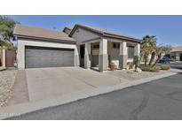 House exterior featuring a two-car garage and well-manicured landscaping at 14306 W Lexington Ave, Goodyear, AZ 85395