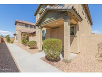 Tan two-story house with front walkway, landscaping, and a covered entryway at 812 E Agua Fria Ln, Avondale, AZ 85323