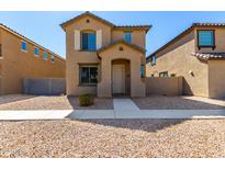 Two-story house with light brown exterior, walkway, and small front yard at 851 E Agua Fria Ln, Avondale, AZ 85323