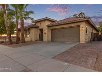 Charming single story home with brick driveway and mature palm trees at 17392 W Grant St, Goodyear, AZ 85338