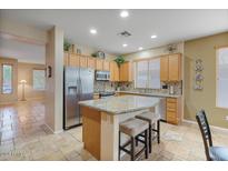 Modern kitchen with granite countertops, stainless steel appliances, and light wood cabinets at 43154 N Outer Banks Dr, Anthem, AZ 85086