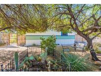 Landscaped front yard with cacti, trees, and a small patio set at 3551 W Ross Ave, Glendale, AZ 85308