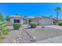 Single story home with a landscaped front yard and solar panels at 15574 W Vista Grande Ln, Surprise, AZ 85374