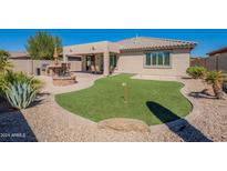 Landscaped backyard oasis with putting green and fire pit at 7527 E Elderberry Way, Gold Canyon, AZ 85118