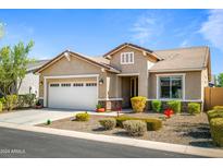 Tan single story home with two car garage and landscaped yard at 20494 W Minnezona Ave, Buckeye, AZ 85396