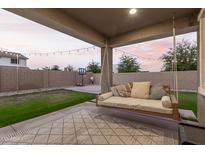 Relaxing backyard with covered patio, swing bed, and basketball hoop at 20442 E Rosa Rd, Queen Creek, AZ 85142