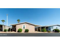 Tan mobile home with covered walkway and landscaping at 11596 W Sierra Dawn Blvd # 36, Surprise, AZ 85378