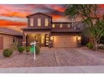 Two-story home with a three-car garage and brick paver driveway at 12687 W Caraveo Pl, Peoria, AZ 85383