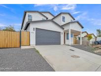 Modern two-story home with gray garage door and wood fence at 13036 N 20Th St, Phoenix, AZ 85022