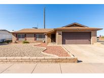 Brick ranch home with a two-car garage and landscaped front yard at 5404 W Puget Ave, Glendale, AZ 85302