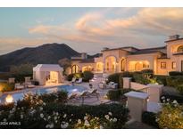 Luxury estate with a large pool, outdoor seating, and mountain views at 10947 E Wingspan Way, Scottsdale, AZ 85255