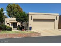 Tan two-car garage home with a landscaped yard at 8638 E Paraiso Dr, Scottsdale, AZ 85255