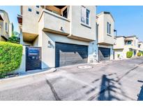 Attached garage with modern dark gray doors and gated entry at 4216 N 27Th St # 106, Phoenix, AZ 85016