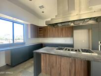 Modern kitchen with dark wood cabinets, stainless steel appliances, and a large island at 507 E Mountain View Rd, Phoenix, AZ 85020