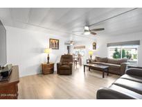 Spacious living room featuring light hardwood floors and comfortable brown leather furniture at 303 S Recker Rd # 45, Mesa, AZ 85206