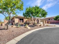 Beautiful tan house with desert landscaping and a long driveway at 3220 W Feather Sound Dr, Anthem, AZ 85086