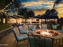Expansive backyard oasis with a pool and fire pit at 6614 W Sweetwater Ave, Glendale, AZ 85304