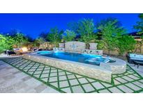 Expansive backyard oasis with a large pool and fire pit at 12789 W Via Caballo Blanco --, Peoria, AZ 85383