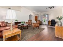 Bright living room with hardwood floors, comfortable seating, and home office area at 8561 E Yucca Blossom Cir, Gold Canyon, AZ 85118