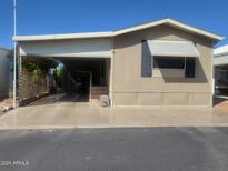 Tan mobile home with carport and golf cart at 17200 W Bell Rd # 1637, Surprise, AZ 85374