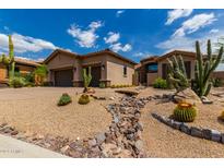 Desert landscaping surrounds this single-story home with a two-car garage at 37143 N Greythorn Cir, Carefree, AZ 85377