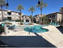 Community pool with lounge chairs and surrounding landscaping at 3236 E Chandler Blvd # 1033, Phoenix, AZ 85048