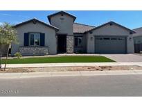 Modern home exterior with two-car garage and landscaping at 16035 W Questa Dr, Surprise, AZ 85387