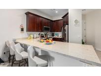 Modern kitchen with dark cabinetry, granite counters, and a breakfast bar at 846 N Pueblo Dr # 126, Casa Grande, AZ 85122