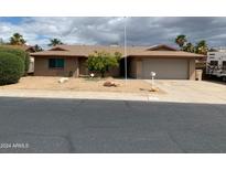 Ranch style home with a two-car garage and mature landscaping at 14207 N 51St Dr, Glendale, AZ 85306