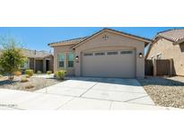 Tan house with a two car garage and landscaping at 16543 W Alameda Rd, Surprise, AZ 85387