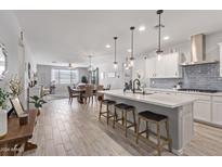 Modern kitchen with island, stainless steel appliances, and open floor plan at 5143 N 183Rd Dr, Litchfield Park, AZ 85340