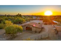 Aerial shot of a ranch with stables, riding arena, and scenic sunset views at 6348 E Wildcat Dr, Cave Creek, AZ 85331