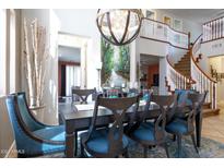 Elegant dining room with a large table, statement lighting, and open staircase at 161 N Silverwood Dr, Casa Grande, AZ 85122